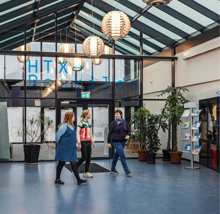 Tre medarbejdere fra Roskilde Tekniske Skole går ned af gang sammen